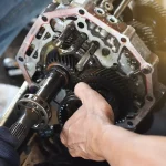 Technician repairing intricate gear components inside a transmission system, showcasing expert-level Transmission Repair Apopka services at Ruben’s Tires.