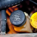 Close-up of a power steering fluid cap under the hood, highlighting essential maintenance linked to professional Suspension Repair Apopka services at Ruben’s Tires.