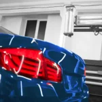 Close-up of a polished blue car with gleaming taillights inside a service bay, showcasing expert detailing and repair work at an Auto Body Shop Apopka.